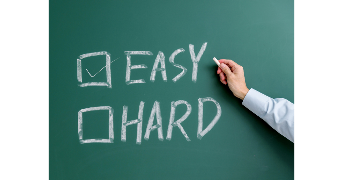 hand holding chalk, chalkboard with two checkboxes, easy and hard. easy is checked.